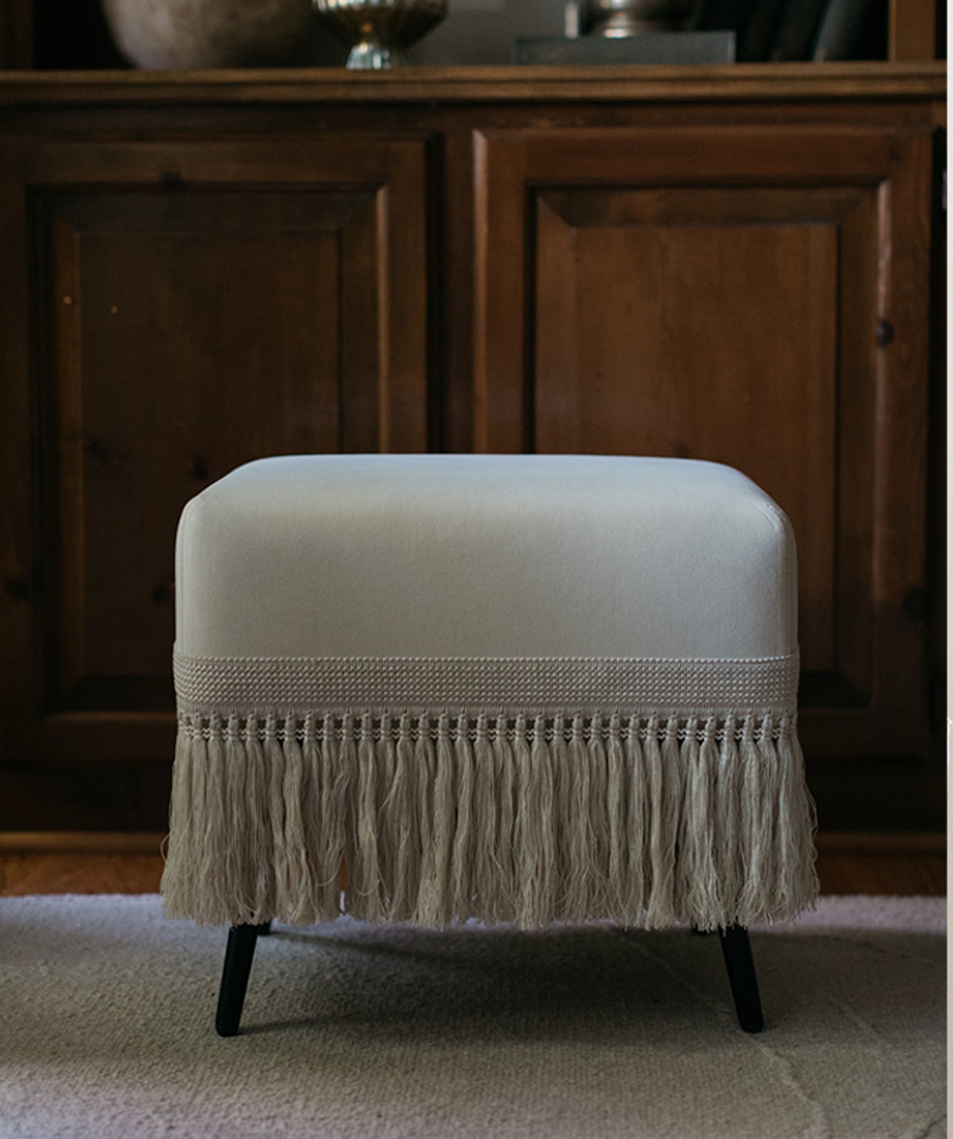 Crema stool styled in elegant living room with neutral decor tones