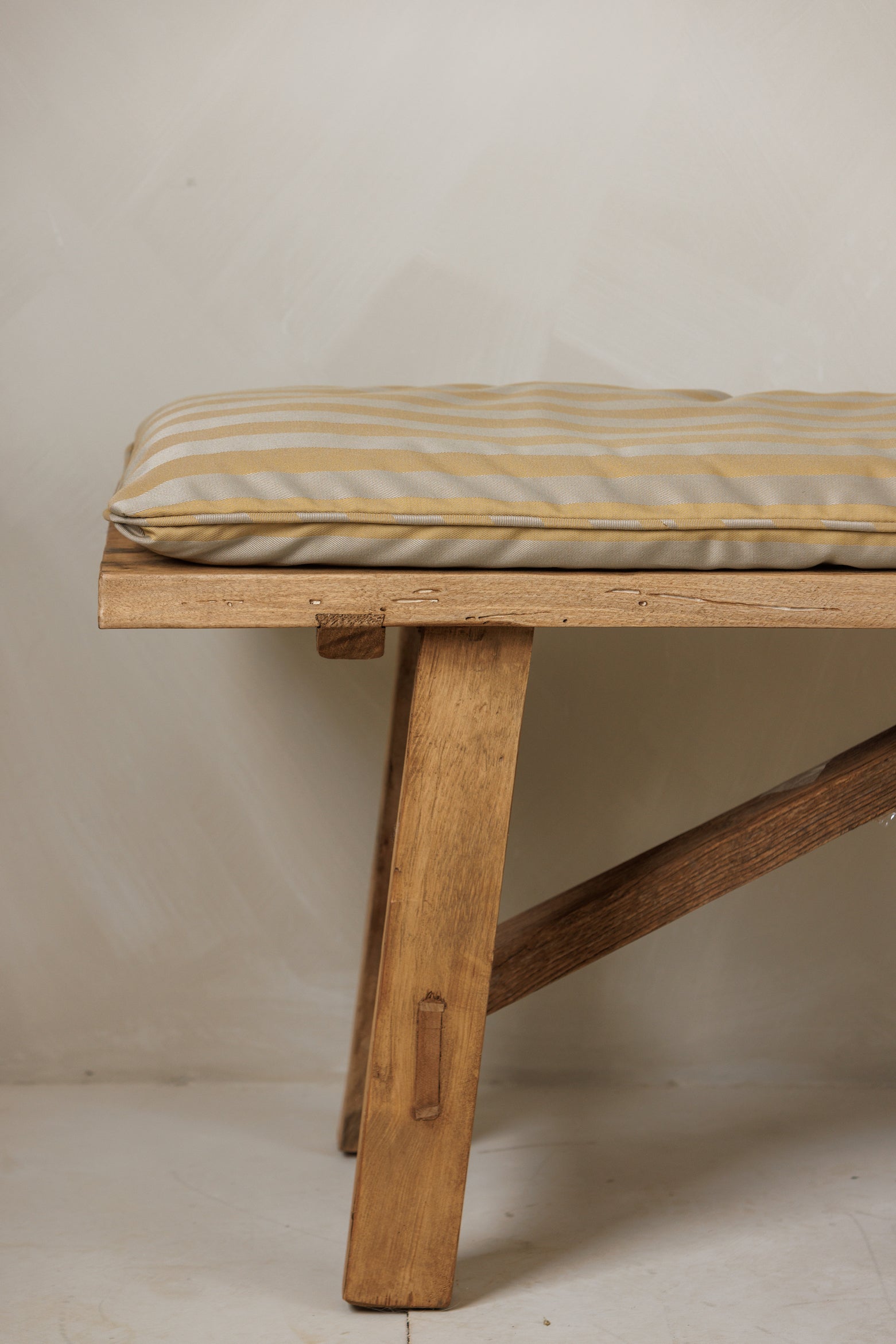 Close-up side view of Fortis Bench with custom striped fabric – Page House Studio
