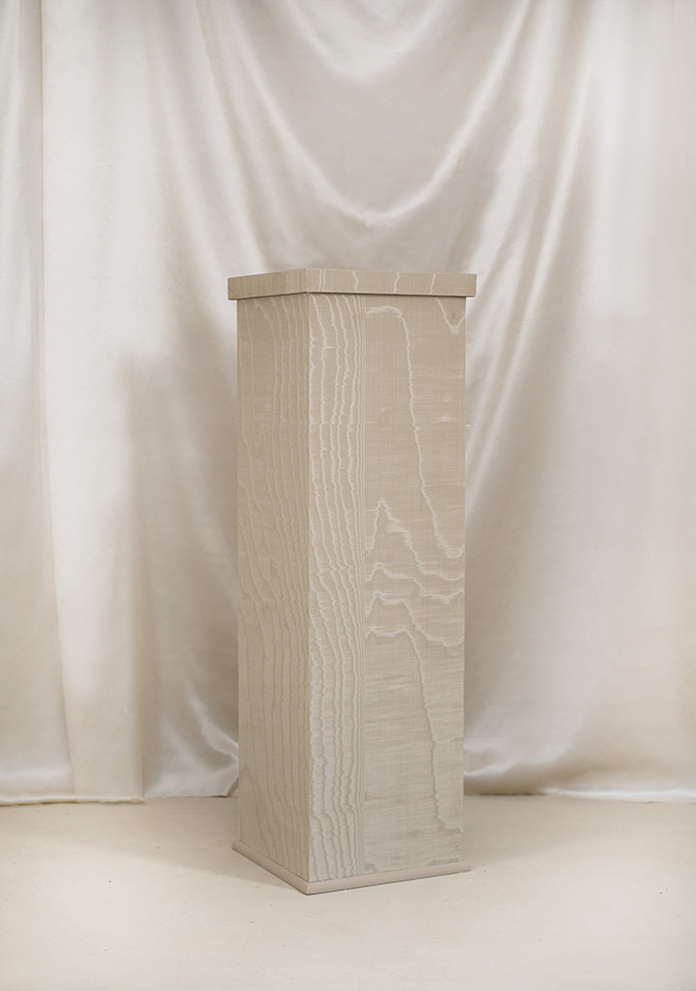 Handmade moiré-wrapped pedestal in stone white finish for modern interiors