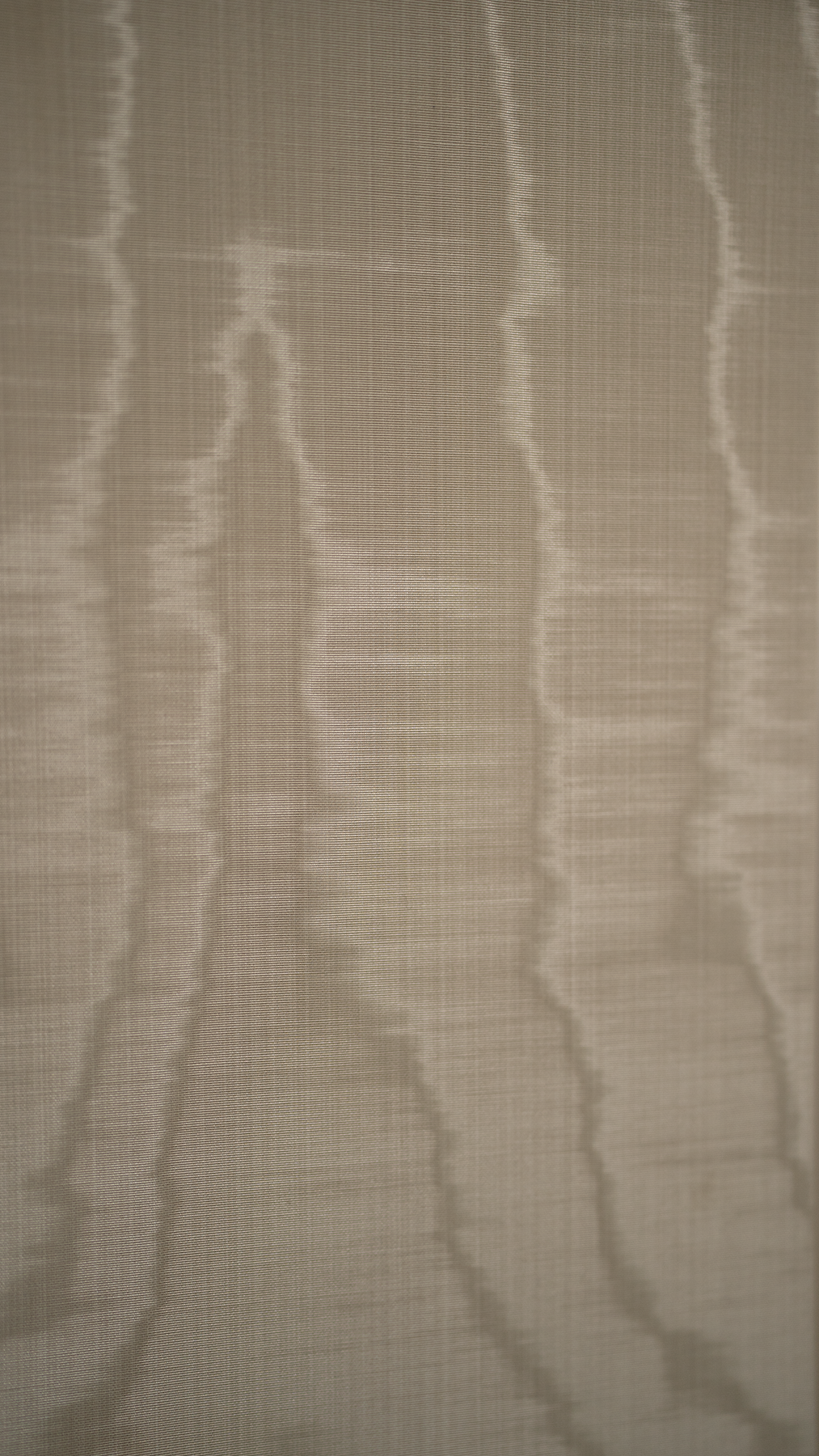 Close-up swatch of moiré wallpaper in stone white finish for pedestal design