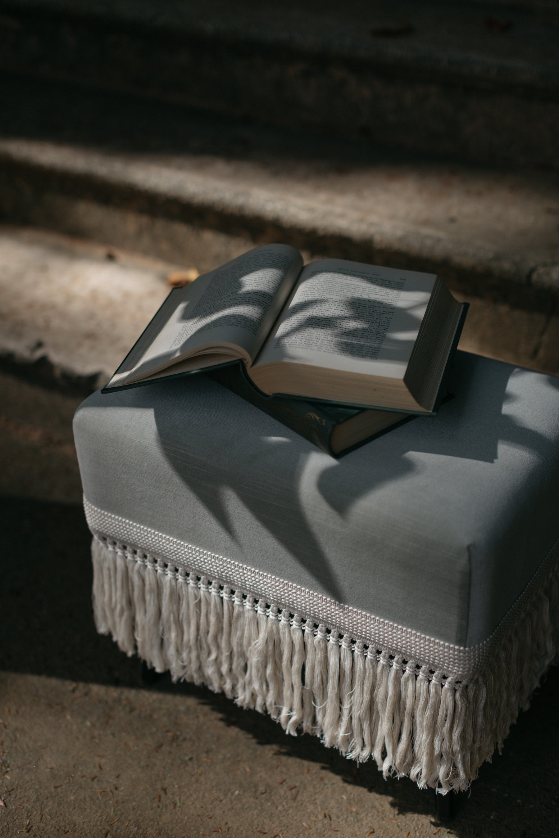 Close-up of Verdigris bluish-green velvet stool featuring ecru fringe detail and styling 
